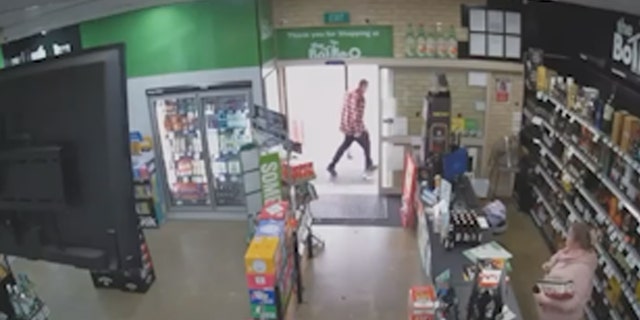 El hombre sale de la tienda después de que el cajero abre la puerta.