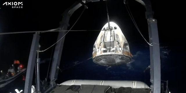Recovery crews lift and secure the SpaceX Dragon capsule
