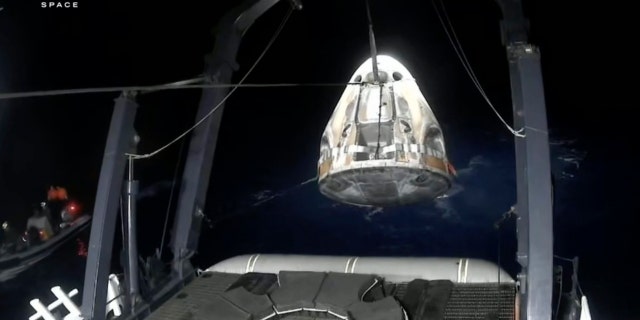 Recovery crews lift and secure the SpaceX Dragon capsule