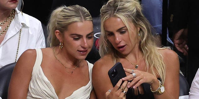The Cavinder twins look at their phone