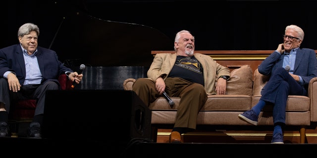 George Wendt in a chair and John Ratzenberger and Ted Danson seated on a couch, all laugh on stage at the ATX TV Festival