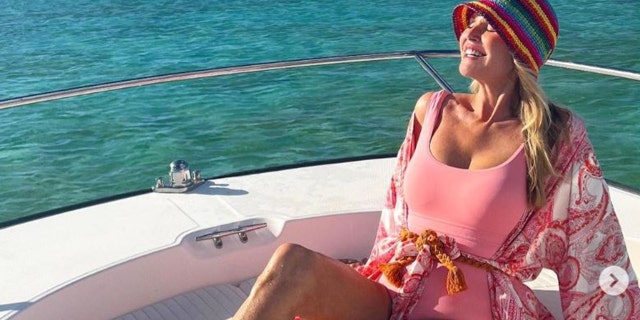 Christie Brinkley wearing a pink bathing suit on a boat