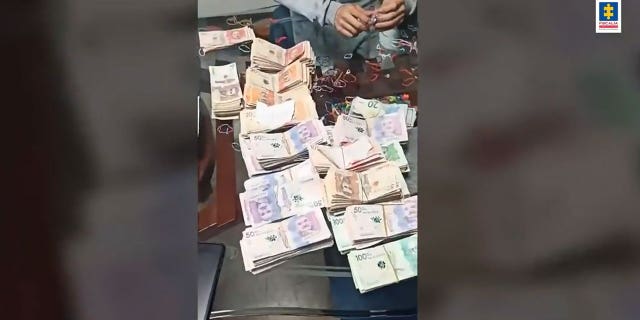 Stacks of money on a table that were seized in a raid in Colombia.