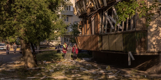 People clean debris from attack