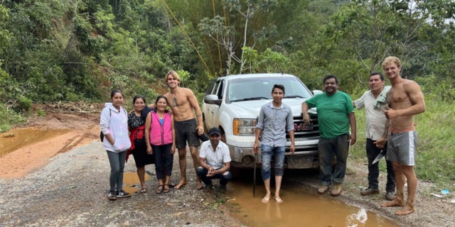 Daniel Penny shown shirtless with a group of locals on a roadtrip in South America.