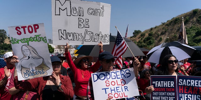 People hold signs during a prayer service