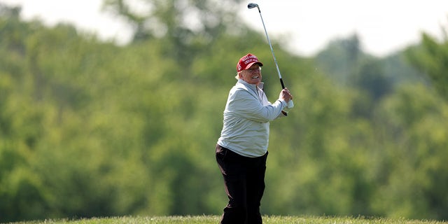 Donald Trump balancea su palo de golf
