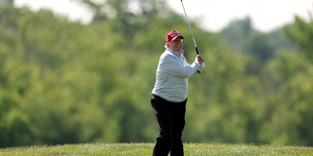 Donald Trump balancea su palo de golf