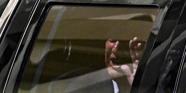 Former US President Donald Trump waves from his vehicle following his appearance at Wilkie D. Ferguson Jr. United States Federal Courthouse