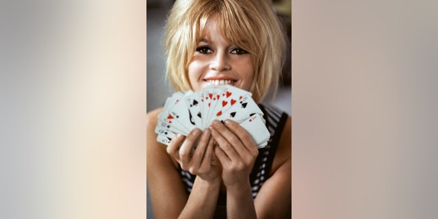 Brigitte Bardot holding a deck of cards