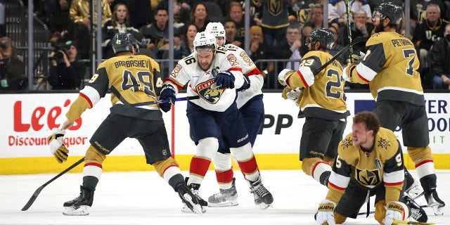 Jack Eichel on ice as players fight behind him