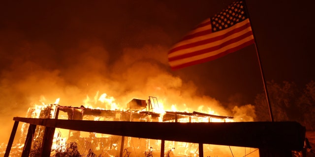 A home burns as the Oak fire moves through the area