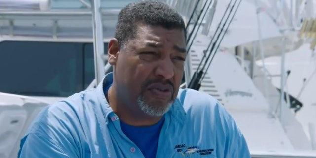Freddy Gamboa in blue shirt interviewed by dock
