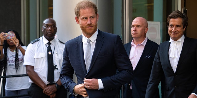 Prince Harry wearing a navy blazer with a light blue tie