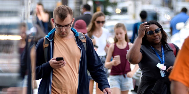 people walking with mobile phones