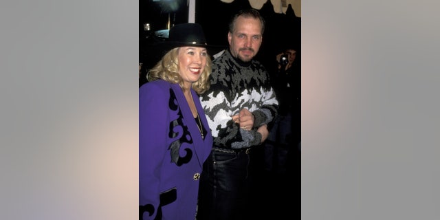 Garth Brooks with his wife, Sandy Mahl, in a purple outfit