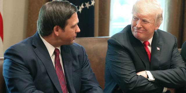 Florida Governor-elect Ron DeSantis (R) sits next to U.S. President Donald Trump