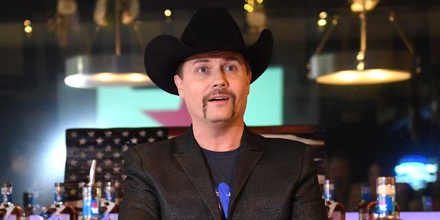 John Rich in a black suit and cowboy hat at Mount Richmore in Nashville