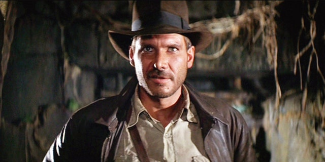 Harrison Ford in a brown leather jacket and brown cowboy hat as Indiana Jones