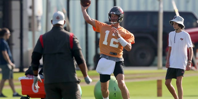 Tom Brady throws a pass as his son looks on