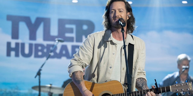 Tyler Hubbard on the Today show wearing a cream jacket and strumming the guitar