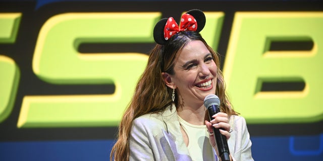 Christy Carlson Romano wearing Minnie ears holding a microphone