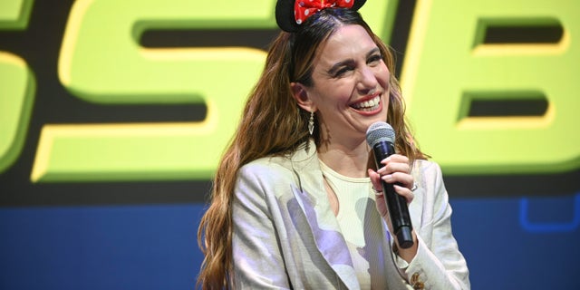 Christy Carlson Romano wearing Minnie ears holding a microphone