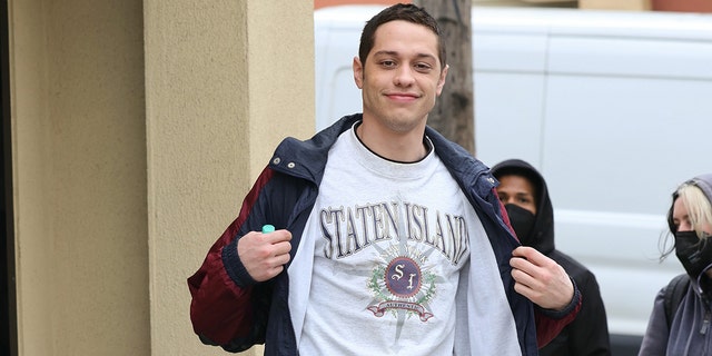 Pete Davidson flashes a Staten Island shirt on the set of his show "Bupkis"