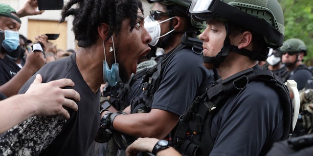 A man menaces a law enforcement officer during a George Floyd-related protest in June 2020 in DC.
