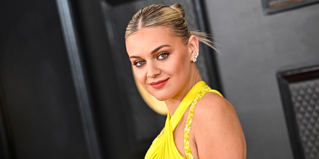 Kelsea Ballerini with an updo and a yellow dress on the Grammy red carpet
