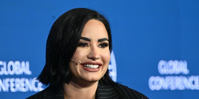 Close up of Demi Lovato smiling with a head mic