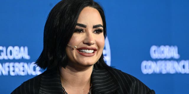 Close up of Demi Lovato smiling with a head mic