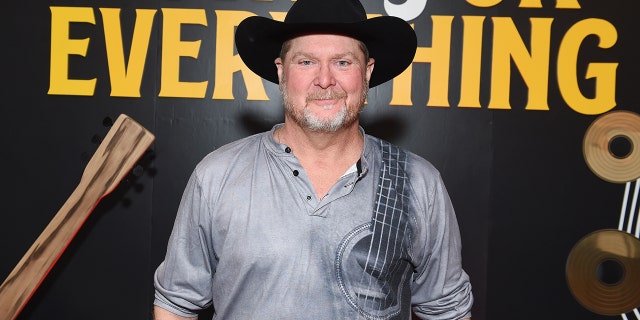 Tracy Lawrence smiles wearing a black cowboy hat ahead of the CMAs