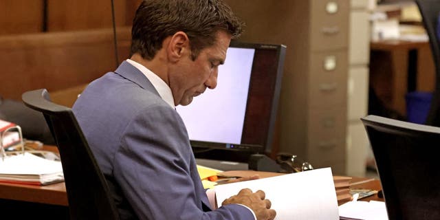 Zerola looking at paper in court