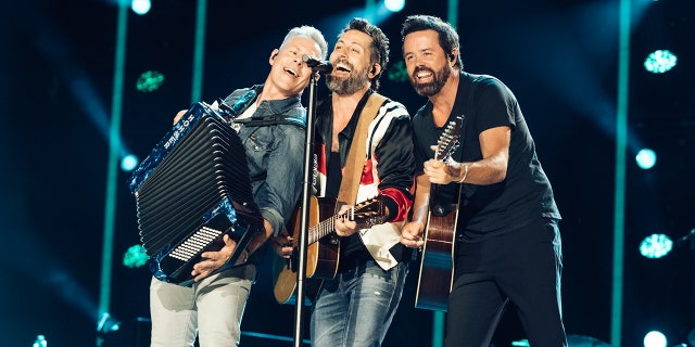 Old Dominion plays on stage at CMA Fest and all three (Trevor Rosen, Matthew, Ramsey and Brad Tursi) lean into the microphone