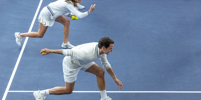 Kate Middleton and Roger Federer both make lunging motions as they toss tennis balls for Wimbledon