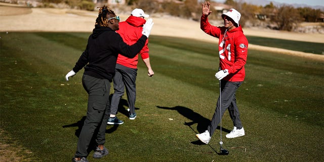 Jordan Poyer high-fives on a golf course