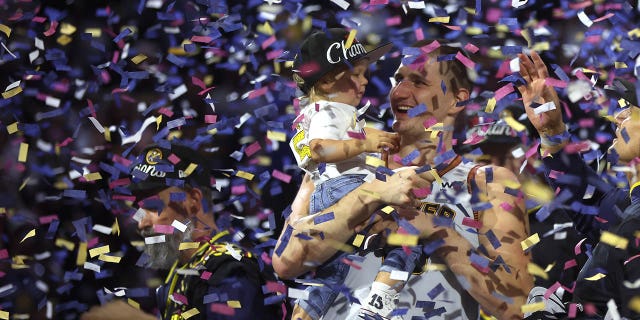 Nikola Jokic celebrates with his son after winning the NBA Championship