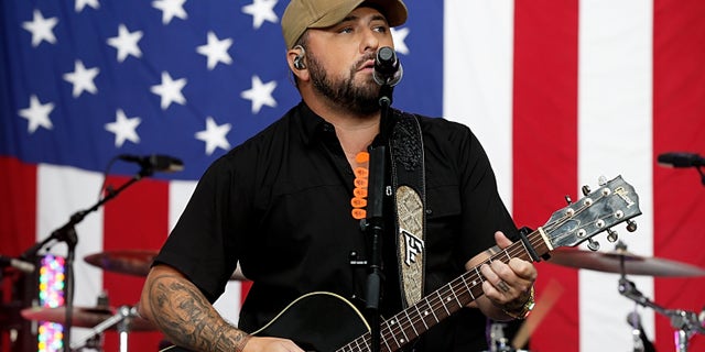 Tyler Farr playing guitar onstage
