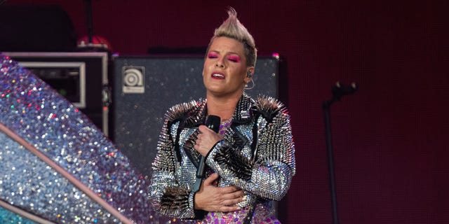 Singer Pink closes her eyes and holds her hands to her chest while on stage in England