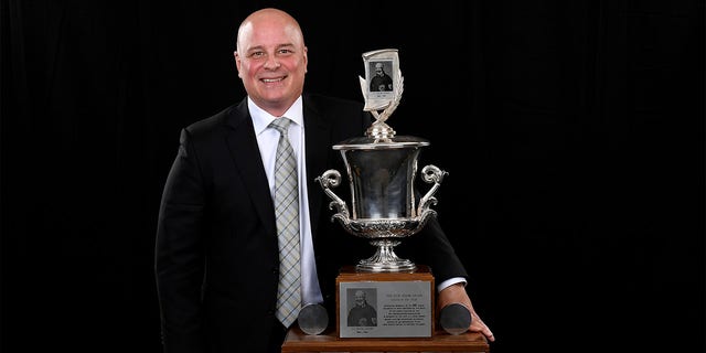 Jim Montgomery poses with The Jack Adams award