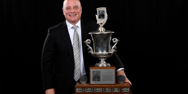 Jim Montgomery poses with The Jack Adams award