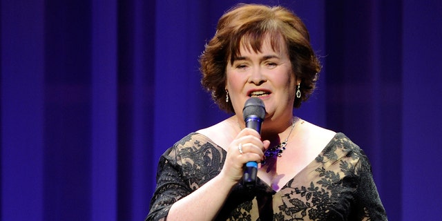 Susan Boyle in an off-shoulder gown sings into the microphone in Las Vegas