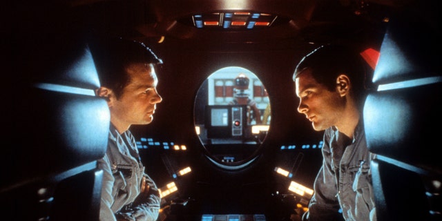 Gary Lockwood and Keir Dullea talk to each other during a scene in what looks like a spaceship from "2001: A Space Odyssey"