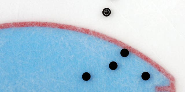 pucks on ice before the start of an NHL game