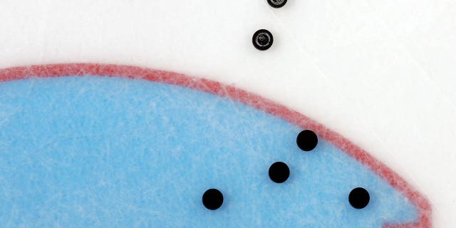 pucks on the ice before the start of an NHL game