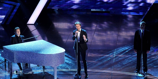 Emanuele Filiberto on stage singing in a tux