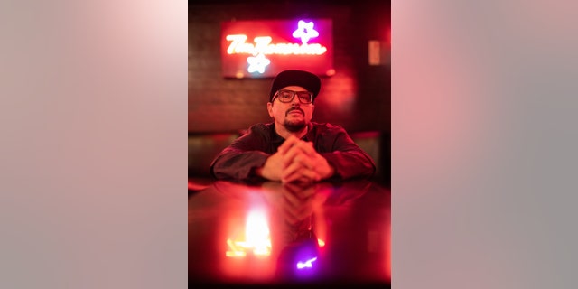 A red photograph of Zak Bagans at the comedy store