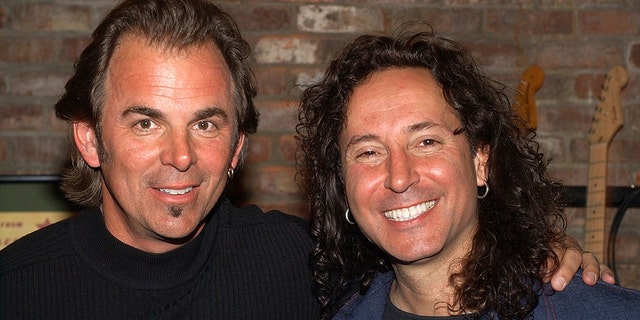 Jonathan Cain and Steve Augeri smiking in black shirts
