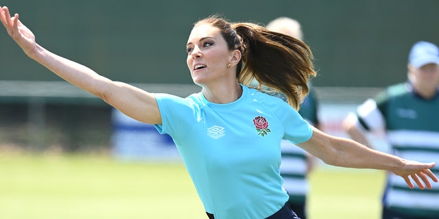 A close-up of Kate Middleton wearing a blue shirt and dark pants